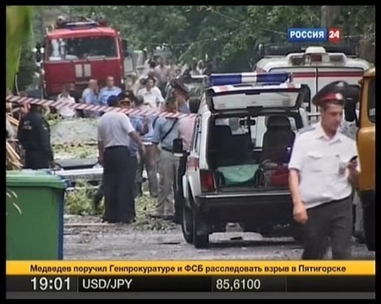 In this image made from TV, police officers and investigators inspect the site of an explosion outside a cafe in downtown Pyatigorsk, a city in Russia's North Caucasus, on Tuesday.